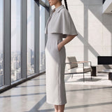 A style comparison of two elegant tailored office sheath midi dresses; the left showcasing a structured vibrant purple dress with a collared capelet sleeve design, and the right featuring a minimalist light grey sleeveless dress with subtle pleated neckline and side pockets.