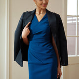 A style comparison of two elegant professional midi dresses with short cap sleeves; the left showcasing a sophisticated teal blue tailored sheath dress with a V-neckline and refined side ruching, and the right featuring the same slimming draping design in a soft pastel lavender lilac color