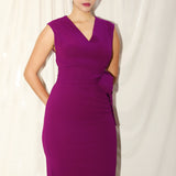 A professional woman wearing a sophisticated magenta v-neck sleeveless midi dress, featuring a tailored slim-fit pencil silhouette for a polished executive office or cocktail look.
