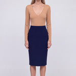 A professional woman wearing a classic navy blue high-waisted tailored pencil midi skirt with subtle front darts, neatly paired with a crisp white long-sleeve button-down shirt for an elegant corporate look.