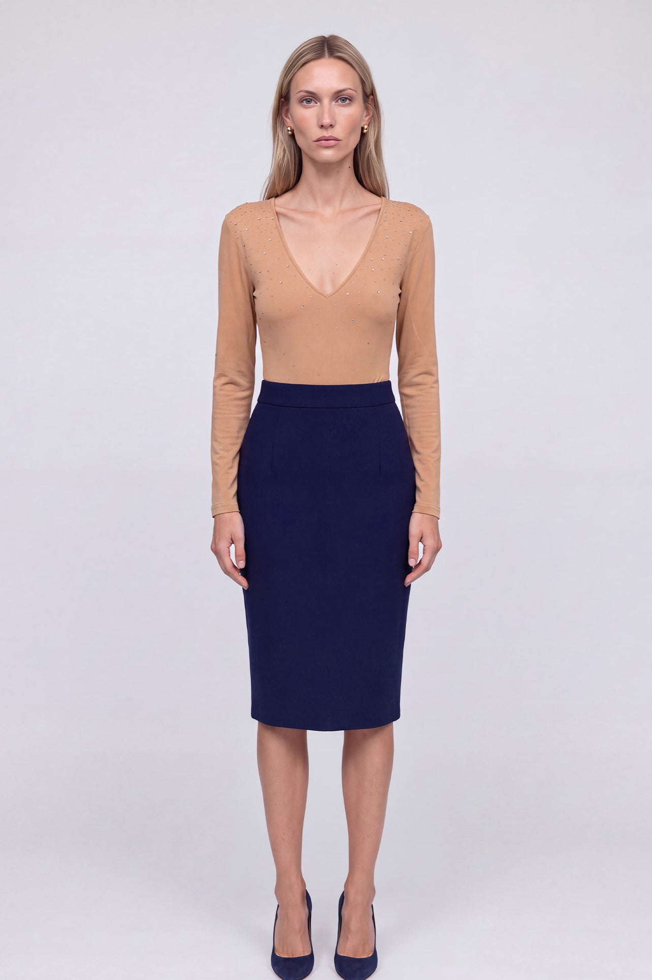 A professional woman wearing a classic navy blue high-waisted tailored pencil midi skirt with subtle front darts, neatly paired with a crisp white long-sleeve button-down shirt for an elegant corporate look.
