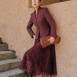 A professional Asian woman wearing glasses and an elegant deep burgundy tailored blazer featuring a sophisticated stand collar with a split V-neckline, structured shoulders, and a clean minimalist front.