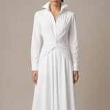 A style comparison of two elegant long-sleeve shirt maxi dresses featuring a unique twist knot waist design; the left showcasing a minimalist solid white dress with a popped collar, and the right featuring a classic blue and white vertical striped dress with a flattering A-line flare skirt.