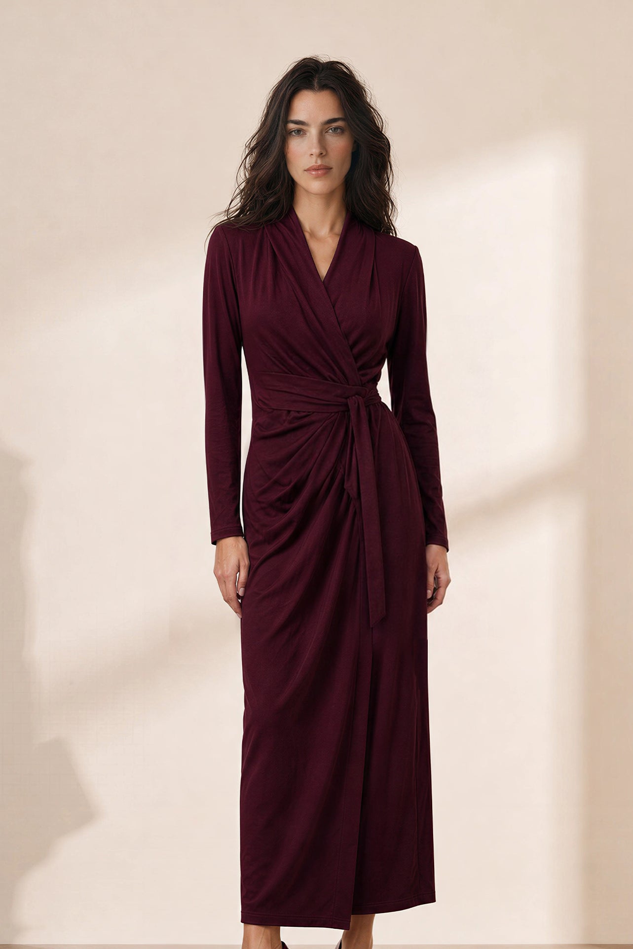 A style comparison of two elegant women's long-sleeve V-neck wrap maxi dresses featuring a flattering side-tie waist and cascading draped ruching; shown on the left in soft oatmeal greige and on the right in rich burgundy wine.