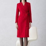 A sophisticated woman walking in London wearing an elegant vibrant red wrap coat dress, featuring a tie-waist belt and notched lapels for a polished executive street style look.