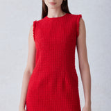 A professional woman wearing a sophisticated vibrant red tweed sleeveless mini dress, featuring a classic round neck, elegant frayed edges, and a slimming black waist belt for a chic holiday or office look.