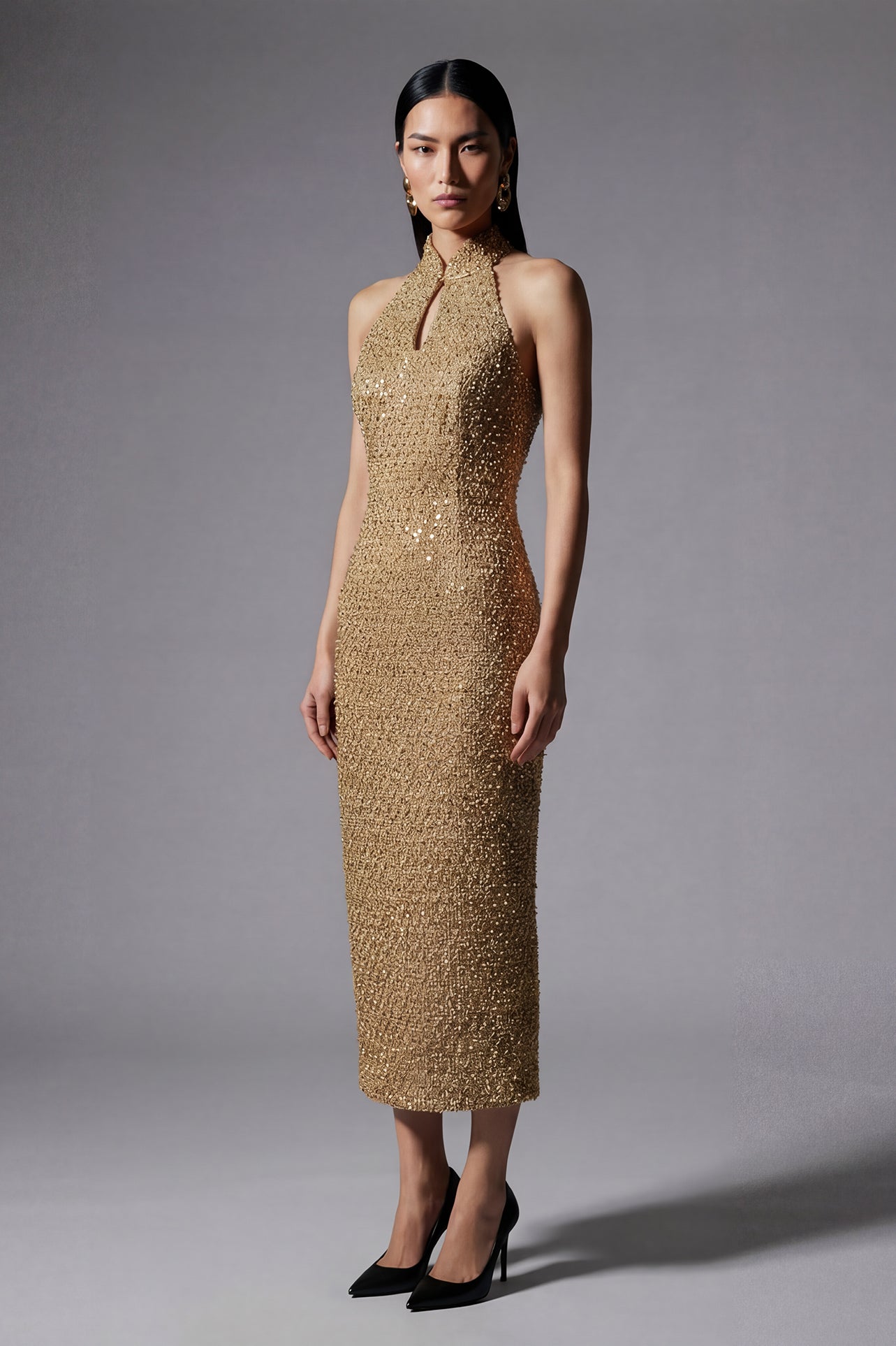 A stunning professional model wearing a luxurious gold sequined halter neck evening gown, featuring a sophisticated keyhole neckline and a slim-fit silhouette for a formal gala look.