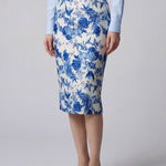 An elegant professional woman wearing a high-waisted pencil skirt featuring a sophisticated blue and white floral porcelain-style print, perfect for a polished office look.