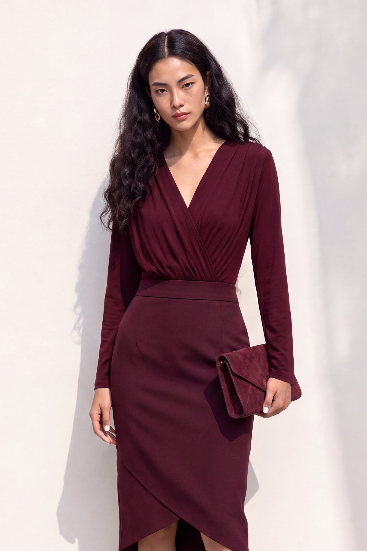 A style comparison of two elegant long-sleeve V-neck wrap tops featuring delicate shoulder pleating and a sleek tucked-in fit; the left in warm camel paired with cream trousers, and the right in deep burgundy paired with black trousers.
