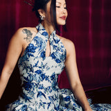 A stunning modern oriental gala dress featuring a classic blue and white porcelain floral print, an elegant halter neck with keyhole detail, and a voluminous A-line full skirt for a sophisticated formal look.