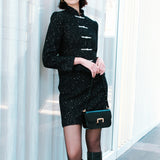 A detailed shot of a woman modeling a sophisticated black woven tweed mini skirt adorned with subtle shimmering crystals, tailored in a sleek high-waisted pencil cut.