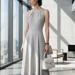 A style comparison of two elegant tailored midi dresses with a flowing high-low hem; the left showcasing a sophisticated light grey dress with a structured collared capelet sleeve, and the right featuring a vibrant purple sleeveless dress with refined pleated neckline and side pockets.