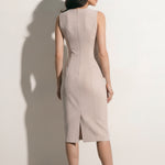 A professional woman modeling an elegant mustard yellow sleeveless sheath dress, featuring a sophisticated crew neckline and a tailored slim fit with princess seams for a polished executive look.