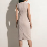 A professional woman modeling an elegant mustard yellow sleeveless sheath dress, featuring a sophisticated crew neckline and a tailored slim fit with princess seams for a polished executive look.