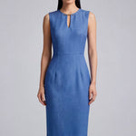 A professional woman modeling an elegant slate blue sleeveless sheath dress, featuring a sophisticated keyhole neckline with a delicate gold metal hardware detail and a tailored slim fit for corporate office wear.