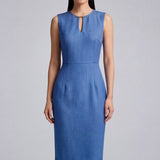 A professional woman modeling an elegant slate blue sleeveless sheath dress, featuring a sophisticated keyhole neckline with a delicate gold metal hardware detail and a tailored slim fit for corporate office wear.