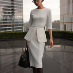 A style comparison of three elegant women modeling tailored three-quarter sleeve crew-neck pencil midi dresses; featured in ivory white and blush pink with a subtle peplum waist and crystal bar detail, and in navy blue with a clean minimalist sheath silhouette.