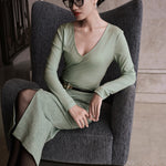 A woman wearing an elegant high-waisted mint green textured pencil midi skirt featuring a clean front waistband and a sophisticated front center slit for a refined corporate chic look.