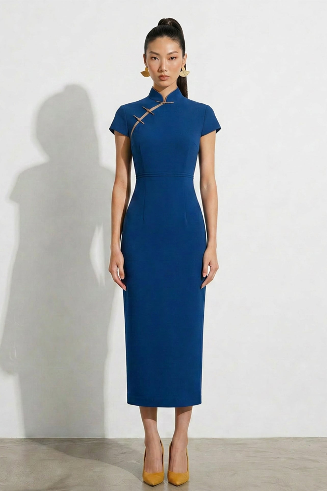 A collection of four professional models of different ages wearing elegant royal blue dresses featuring modern Chinese elements, including mandarin collars, traditional knot buttons, and diverse silhouettes from sleek sheaths to pleated A-line skirts.