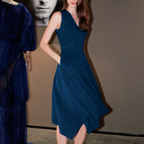 A professional woman modeling an elegant royal blue sleeveless V-neck dress, featuring a tailored fit-and-flare silhouette and a flowing midi A-line skirt for a sophisticated office or social look.