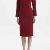 A professional woman wearing a sophisticated black long-sleeve midi dress, featuring a unique notched square neckline and a tailored slim-fit pencil silhouette for a polished executive office look.