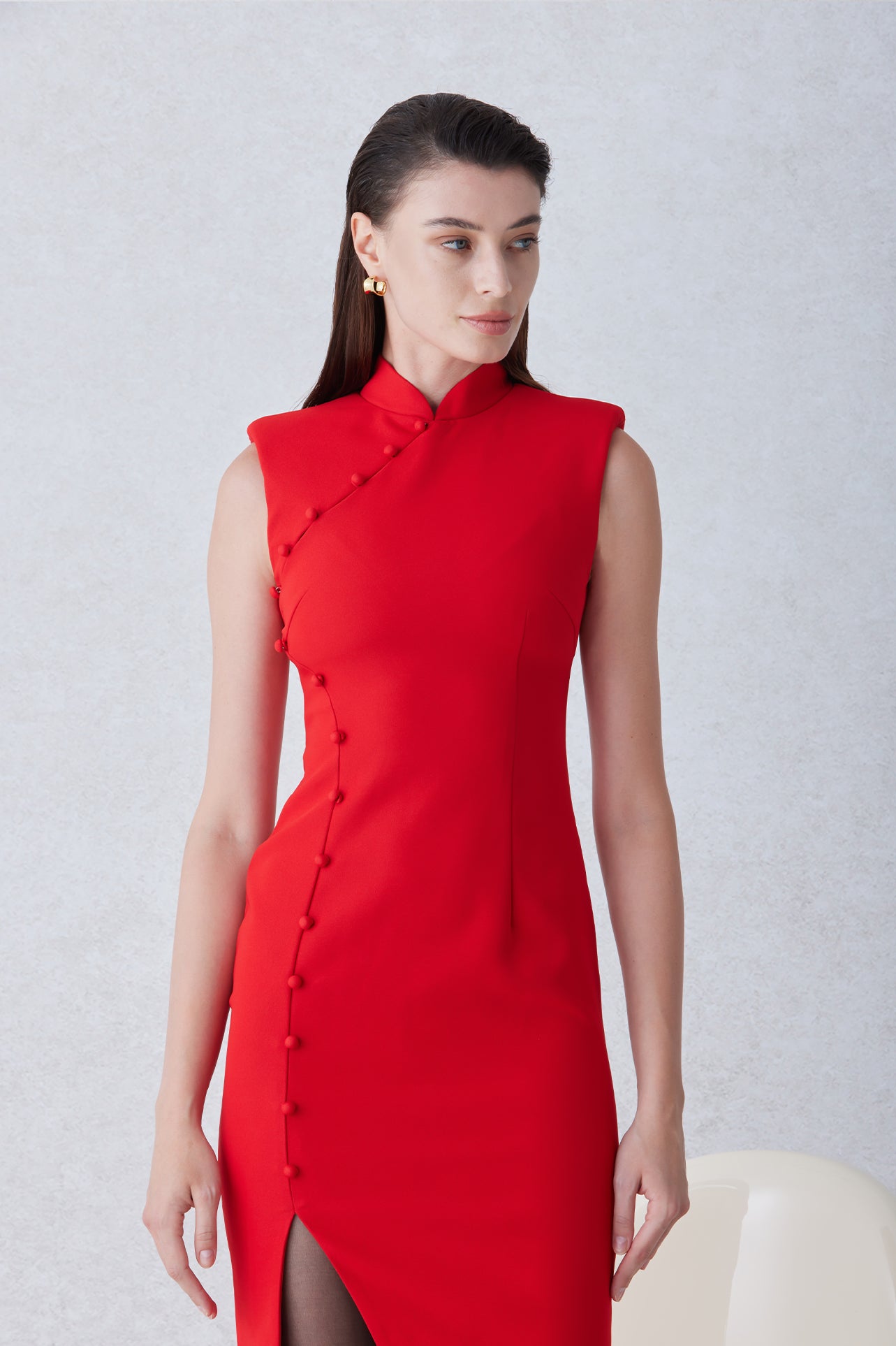 A professional woman wearing a sophisticated black modern qipao, featuring a classic mandarin collar, sleeveless slim-fit silhouette, and elegant side buttons with a high-low slit for a timeless oriental chic look.