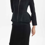 A professional woman wearing a sophisticated cream tweed skirt suit, featuring a tailored jacket with a modern front zipper and an elegant stand collar for a polished executive office look.