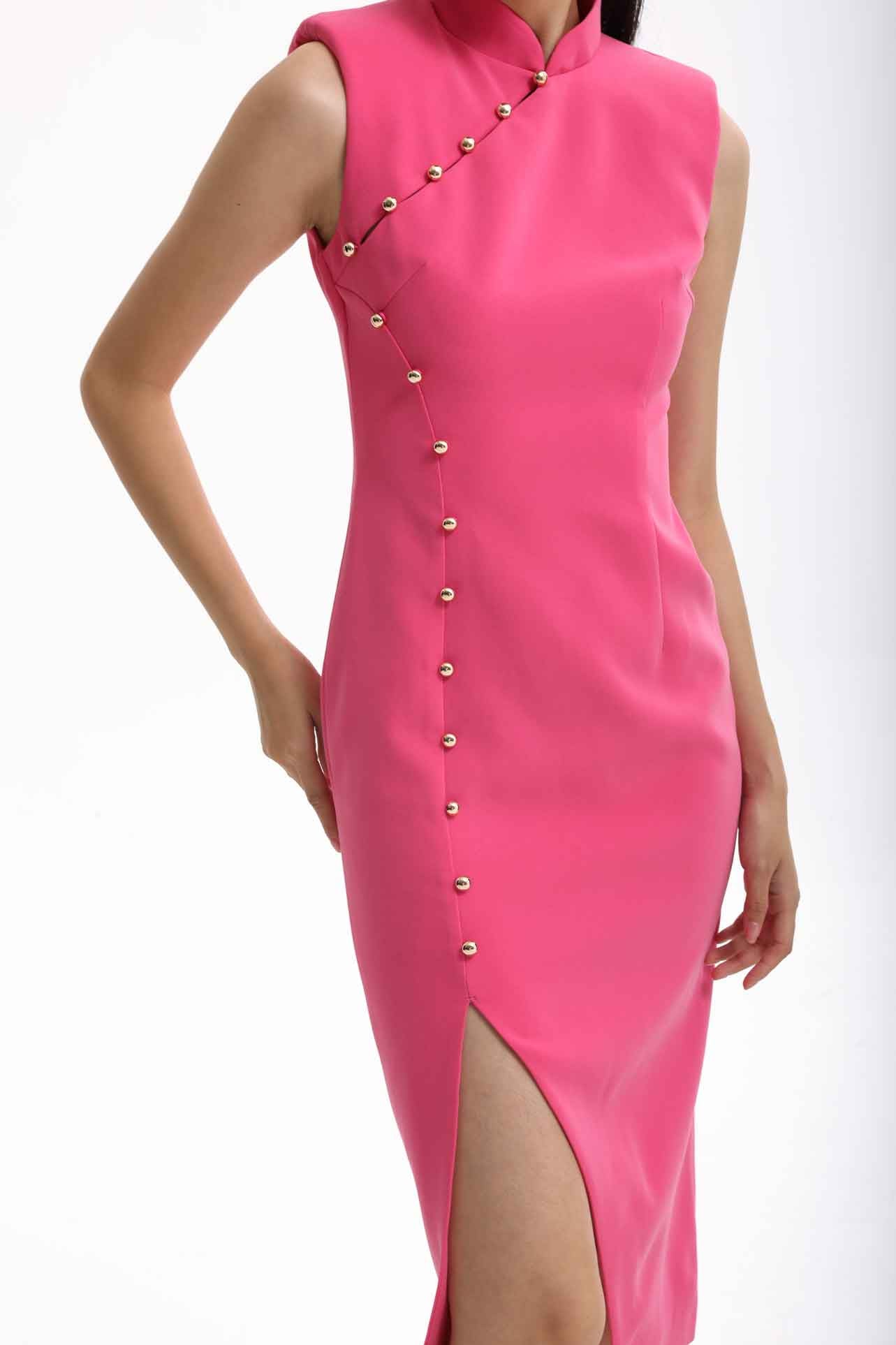 A professional woman wearing a vibrant hot pink modern qipao dress, featuring a classic mandarin collar, sleeveless design, and elegant gold button side-fastening with a sophisticated slit for an oriental chic look.