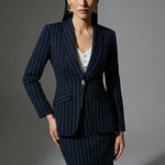 A professional woman wearing a sophisticated navy blue pinstripe suit, featuring a tailored single-button blazer and a matching midi pencil skirt with a front slit for an elegant executive office look.