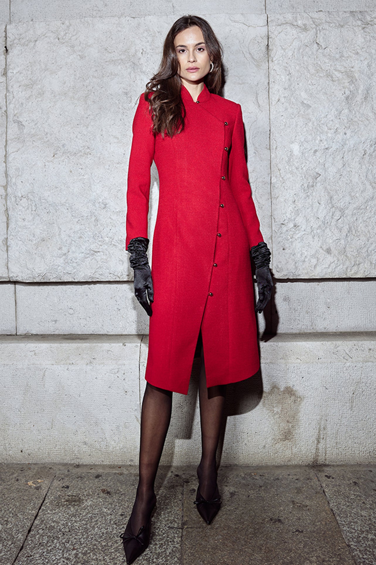 A professional woman smiling in a stunning festive red coat dress, featuring a stand-up mandarin collar with a large 3d rose ornament and an elegant side-button closure, perfect for a Christmas or holiday formal event.