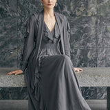A style comparison of two elegant long-sleeve chiffon maxi dresses; the left showcasing a vibrant purple dress with a deep V-neckline and tiered ruffles along the sleeves, and the right featuring a sophisticated grey version styled with a matching neck scarf and smocked waistband.