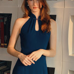 A collection of four professional models of different ages wearing elegant royal blue dresses featuring modern Chinese elements, including mandarin collars, traditional knot buttons, and diverse silhouettes from sleek sheaths to pleated A-line skirts.