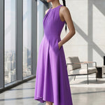 A style comparison of two elegant tailored midi dresses with a flowing high-low hem; the left showcasing a sophisticated light grey dress with a structured collared capelet sleeve, and the right featuring a vibrant purple sleeveless dress with refined pleated neckline and side pockets.