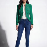 A professional woman wearing a stunning vibrant green blazer, featuring a traditional mandarin collar and elegant frog button detailing for a modern oriental-inspired executive look.