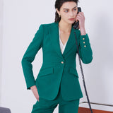 A professional woman wearing a sophisticated emerald green tailored blazer, featuring a slim-fit silhouette, notched lapels, and flap pockets, styled elegantly with a patterned silk scarf for a corporate office look.