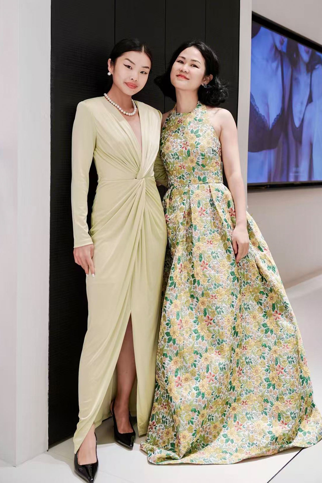 A sophisticated woman wearing a vibrant magenta long-sleeve dress, featuring a plunging V-neckline and an elegant knot-front twist at the waist for a stunning evening gala look.