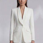 Two professional women showcasing high-end executive business suits: one in a crisp white pant suit with a shawl lapel blazers, and the other in a sophisticated camel skirt suit with a tailored vest, perfect for formal corporate settings.