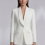 Two professional women showcasing high-end executive business suits: one in a crisp white pant suit with a shawl lapel blazers, and the other in a sophisticated camel skirt suit with a tailored vest, perfect for formal corporate settings.