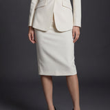 A professional woman wearing a sophisticated high-waisted pencil skirt in a cream white color, featuring a tailored slim fit and knee-length hem for an elegant office look.
